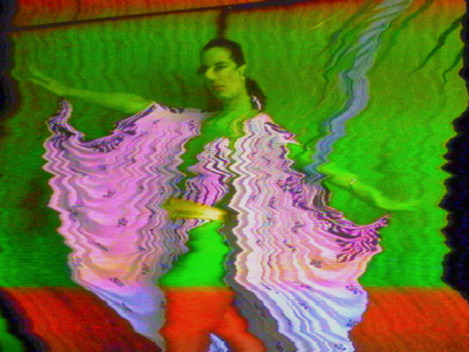 The same model with the cape torn into wavy slabs, the cape pink, the wall behind her bright green and a band of red across her legs.